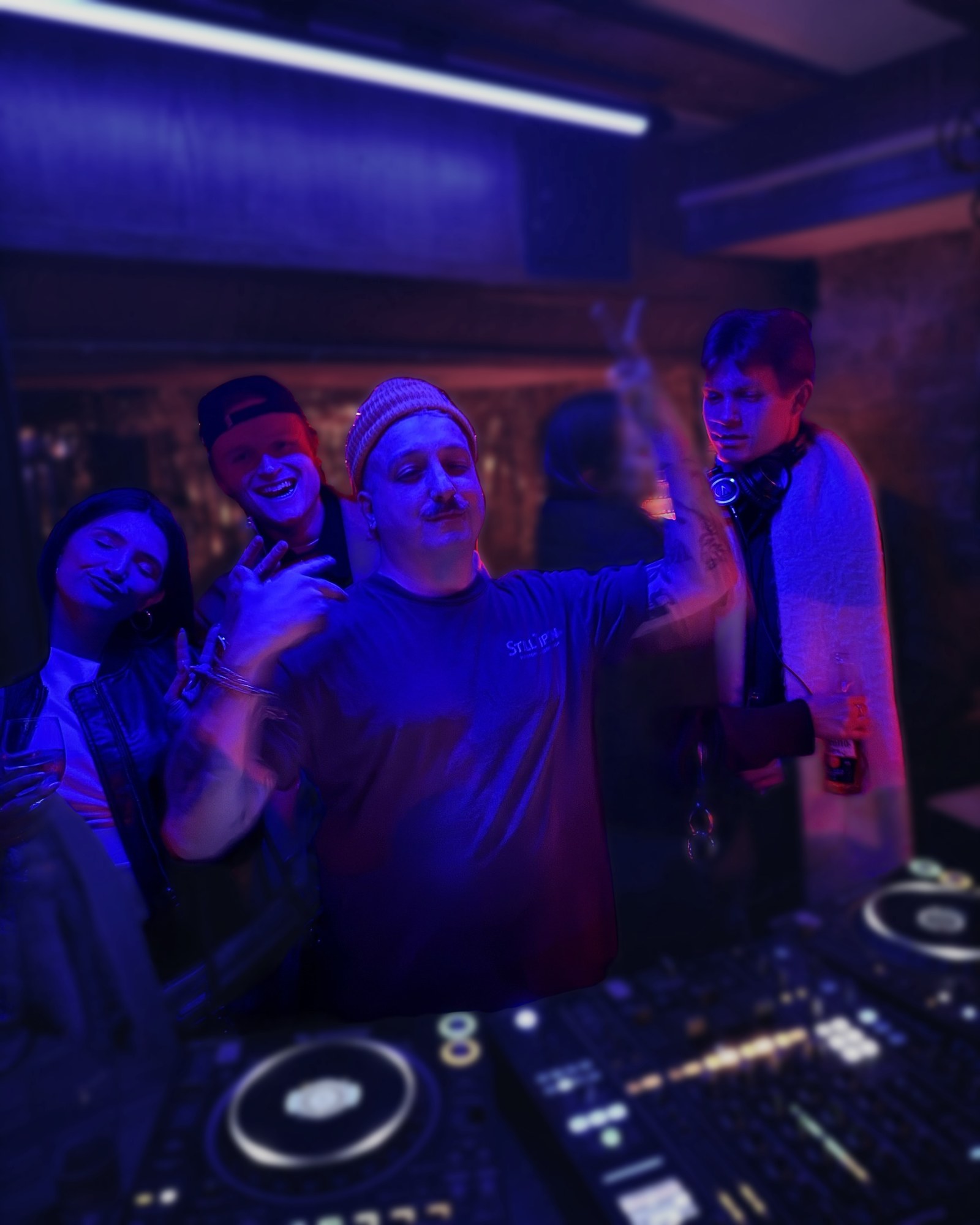 DapSoul and friends packed behind the decks under blue light