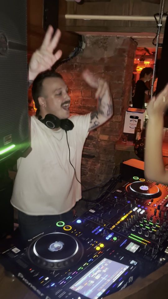 DapSoul throwing a hand up over the CDJs